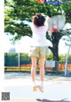 A woman jumping in the air to catch a basketball.