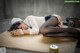 A woman laying on the ground next to a can of beer.