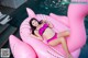 A woman in a pink bikini laying on an inflatable flamingo.