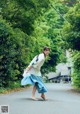 A woman walking down a street with a bag in her hand.