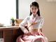 A woman in a pink and white hanbok sitting on a table.