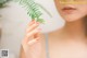 A woman holding a fern leaf in her hand.