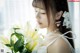 A woman in a white dress holding a bouquet of white flowers.